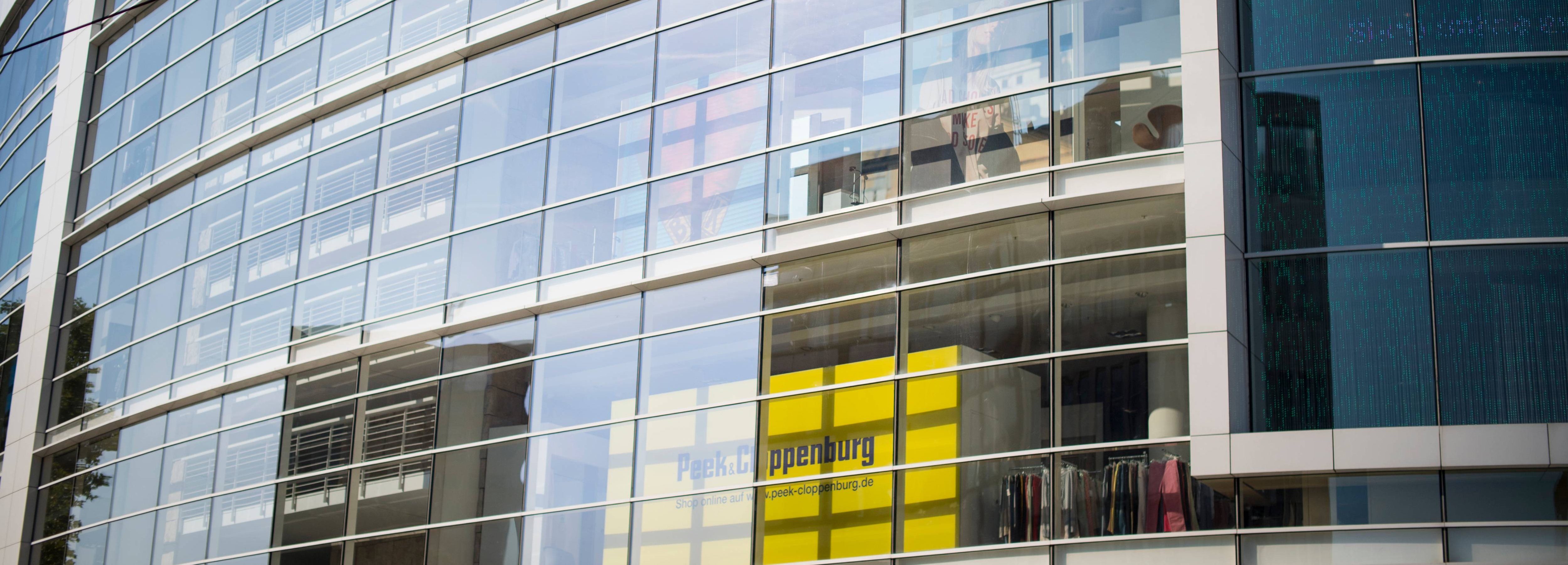 Blick auf die Fassade eines modernen, verglasten P&C Verkaufshauses.