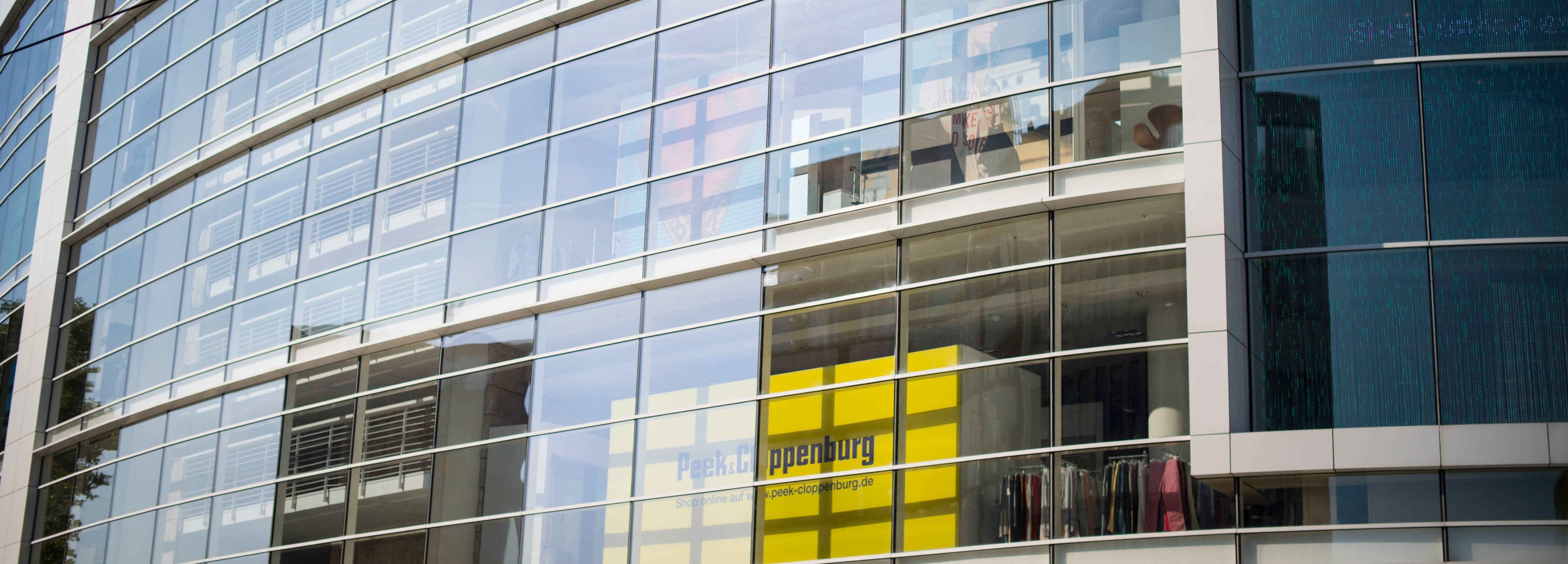 Blick auf die Fassade eines modernen, verglasten P&C Verkaufshauses.