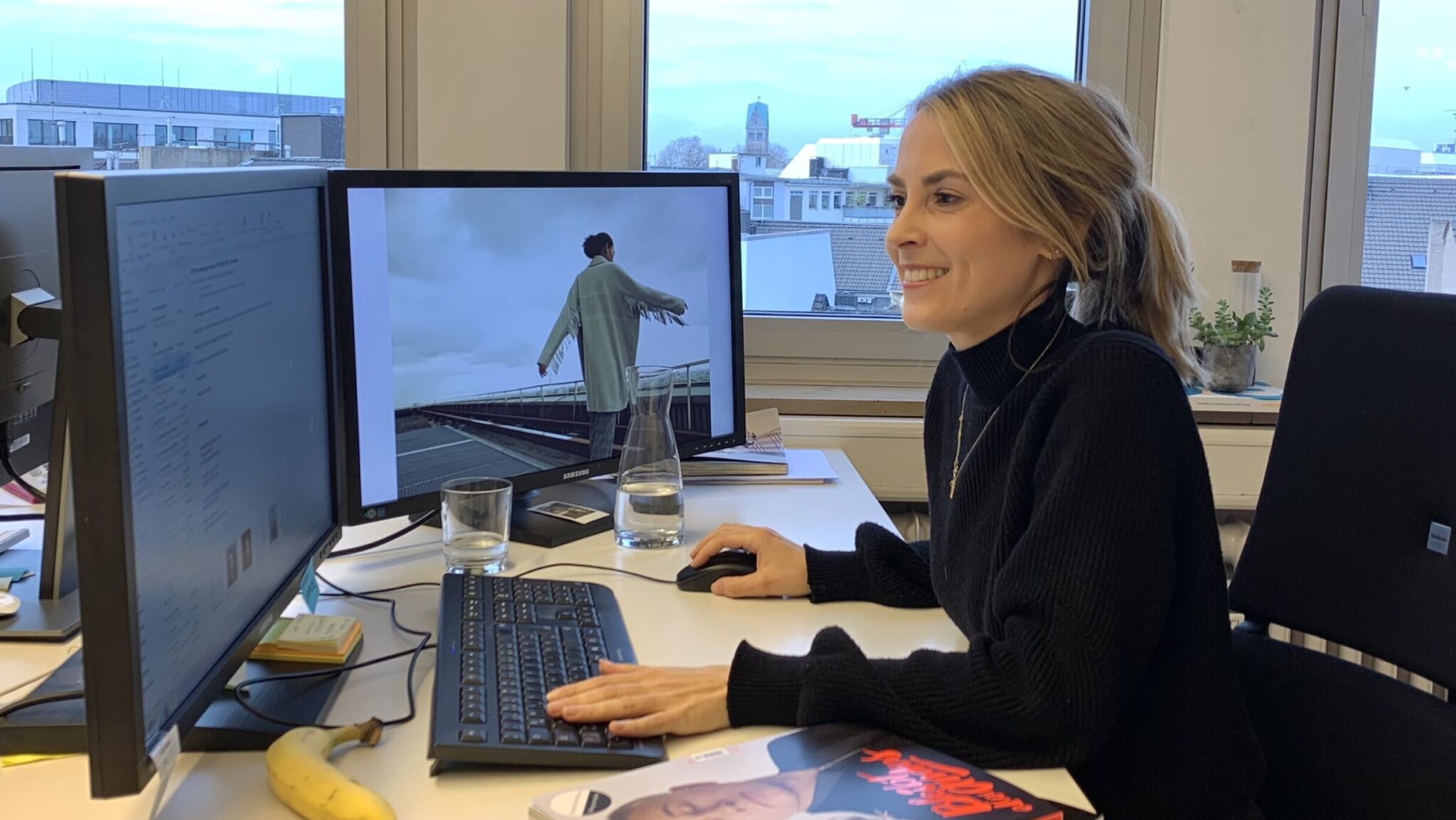 Julia an ihrem Arbeitsplatz mit zwei Bildschirmen. 